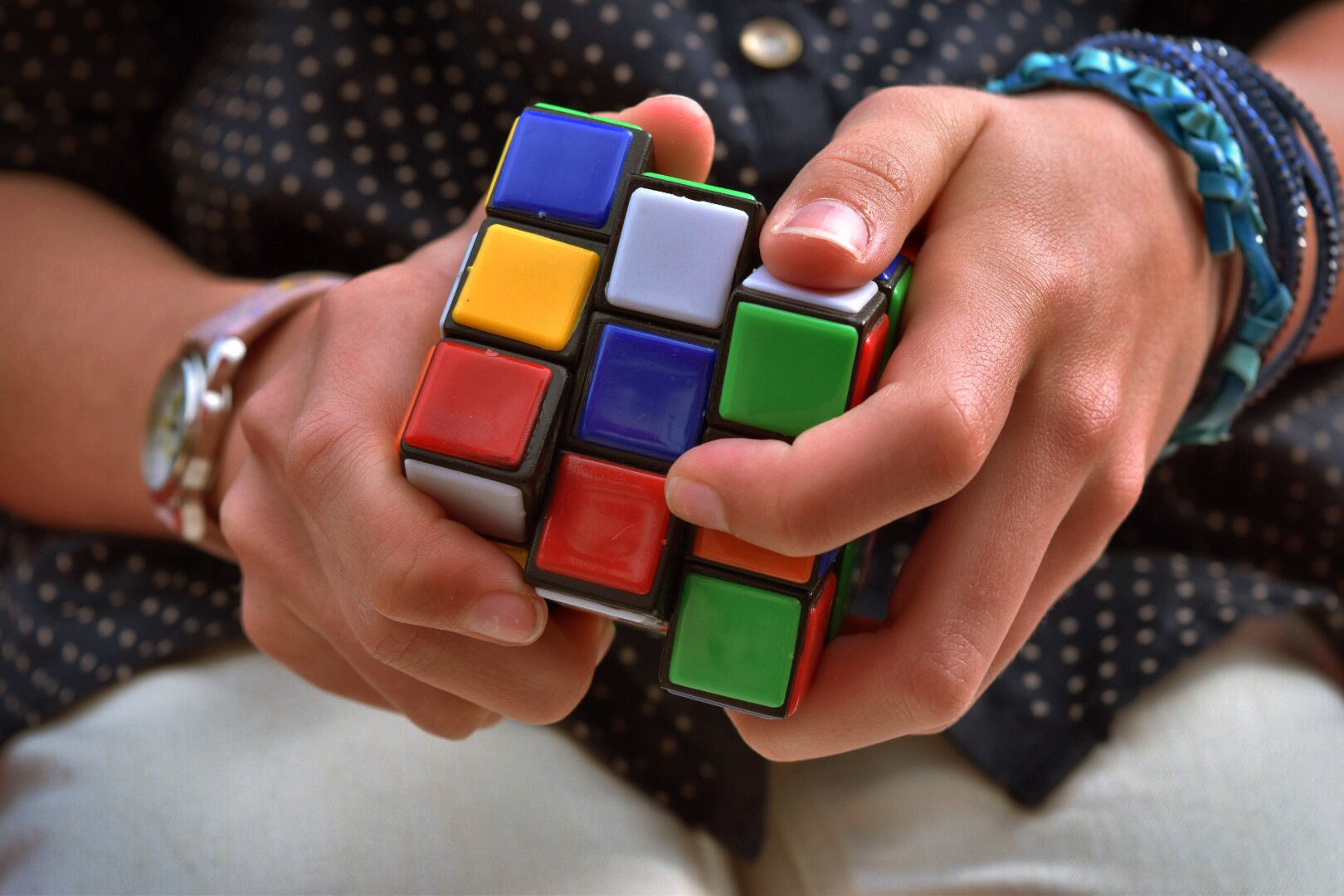 Человек собирает кубик Рубика